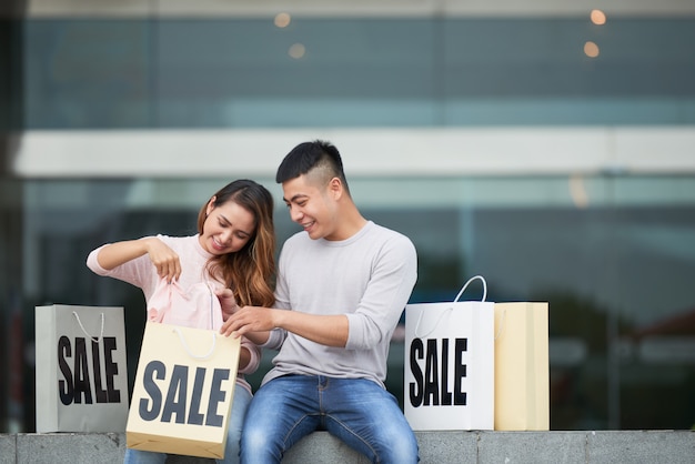 Pareja joven compartiendo compras en venta