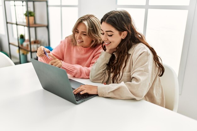 Pareja joven comprando usando laptop y tarjeta de crédito en casa.