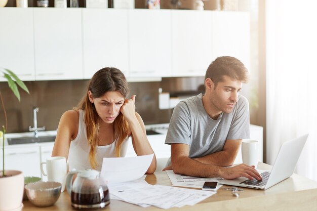 Pareja joven comprobando su presupuesto familiar