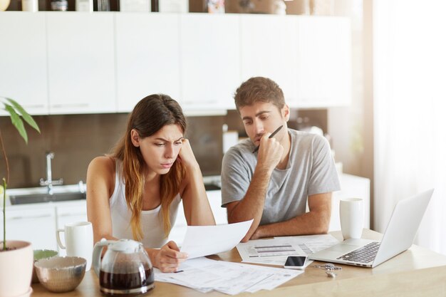 Pareja joven comprobando su presupuesto familiar