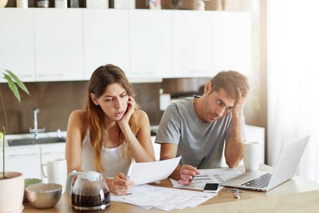 Pareja joven comprobando su presupuesto familiar