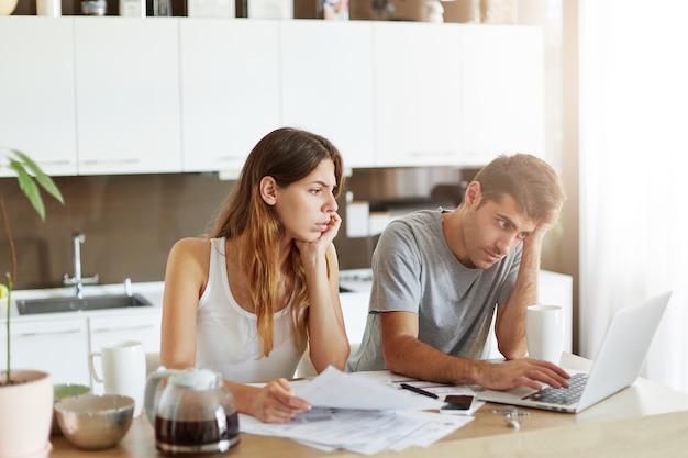 Pareja joven comprobando su presupuesto familiar