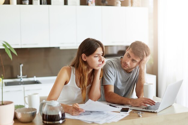 Pareja joven comprobando su presupuesto familiar