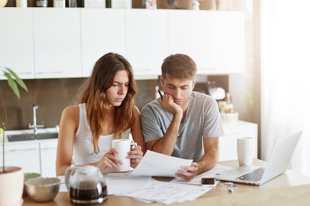 Pareja joven comprobando su presupuesto familiar