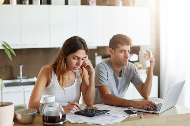 Pareja joven comprobando su presupuesto familiar