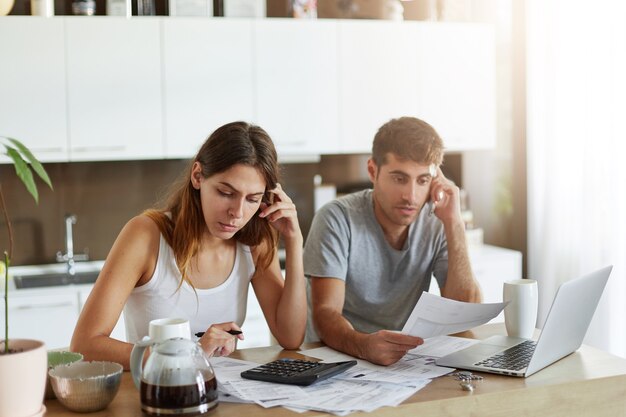Pareja joven comprobando su presupuesto familiar