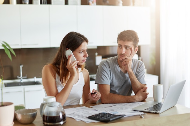 Pareja joven comprobando su presupuesto familiar