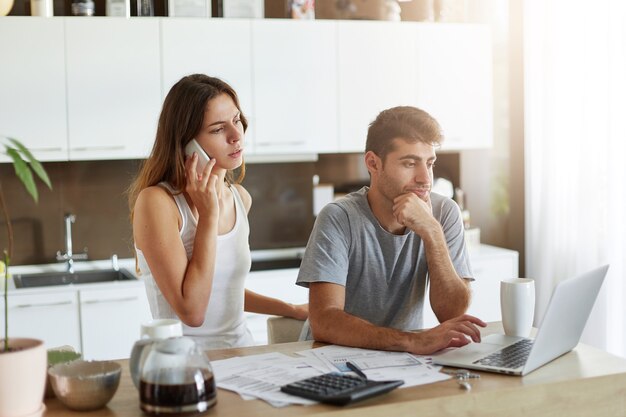 Pareja joven comprobando su presupuesto familiar