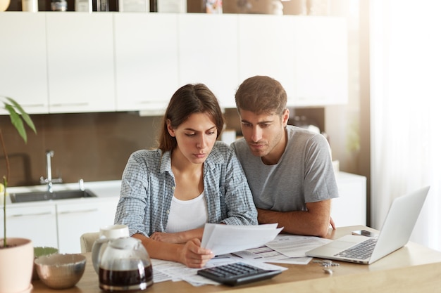 Pareja joven comprobando su presupuesto familiar