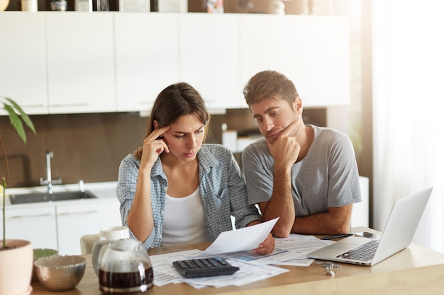 Pareja joven comprobando su presupuesto familiar