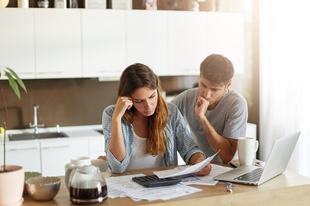 Pareja joven comprobando su presupuesto familiar