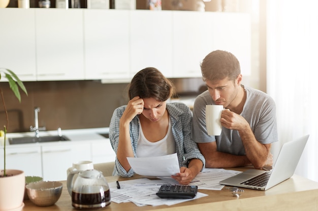 Pareja joven comprobando su presupuesto familiar