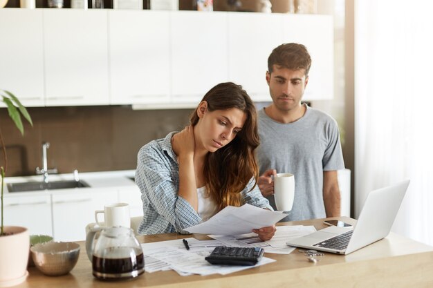 Pareja joven comprobando su presupuesto familiar