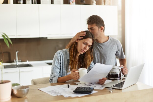 Pareja joven comprobando su presupuesto familiar