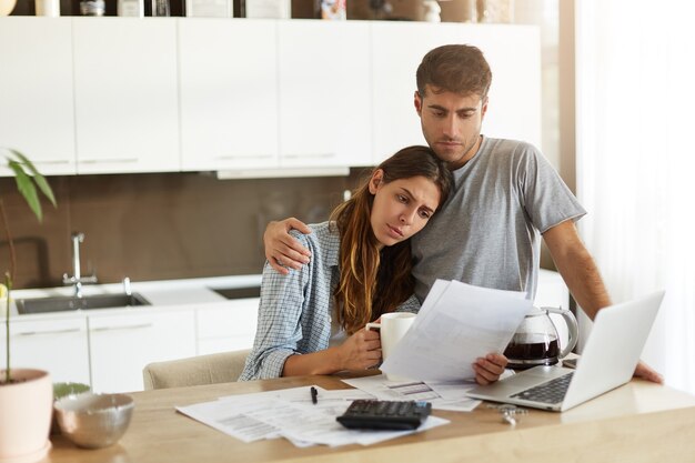 Pareja joven comprobando su presupuesto familiar