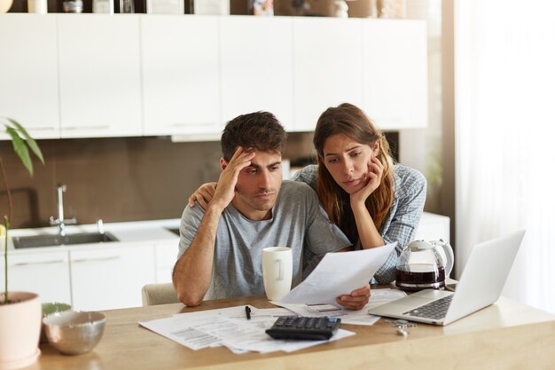 Pareja joven comprobando su presupuesto familiar