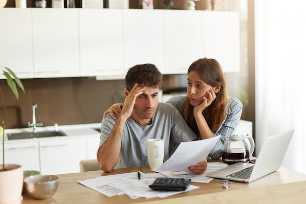 Pareja joven comprobando su presupuesto familiar