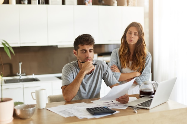 Pareja joven comprobando su presupuesto familiar