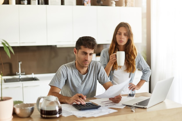 Pareja joven comprobando su presupuesto familiar