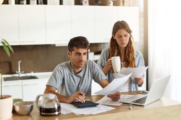 Pareja joven comprobando su presupuesto familiar