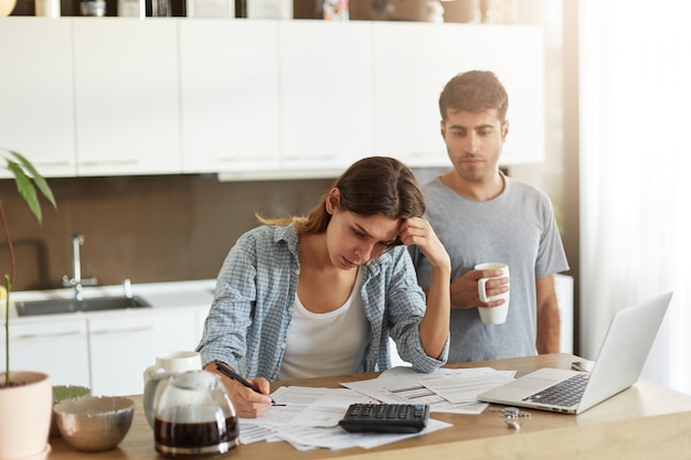 Pareja joven comprobando su presupuesto familiar