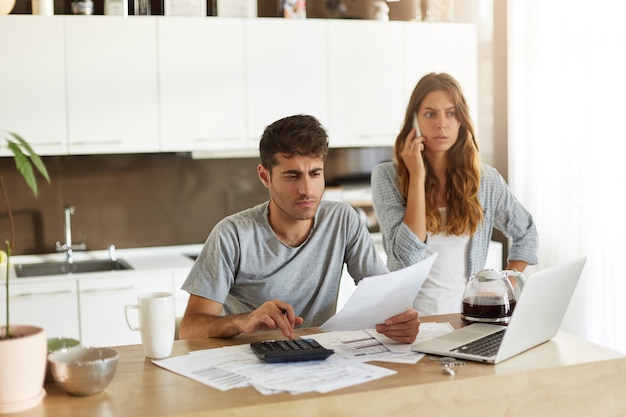 Pareja joven comprobando su presupuesto familiar