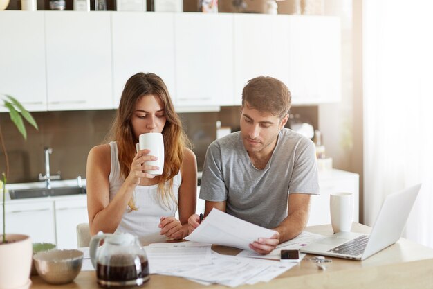 Pareja joven comprobando su presupuesto familiar