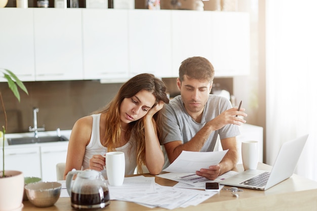 Pareja joven comprobando su presupuesto familiar