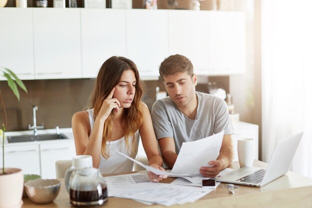 Pareja joven comprobando su presupuesto familiar