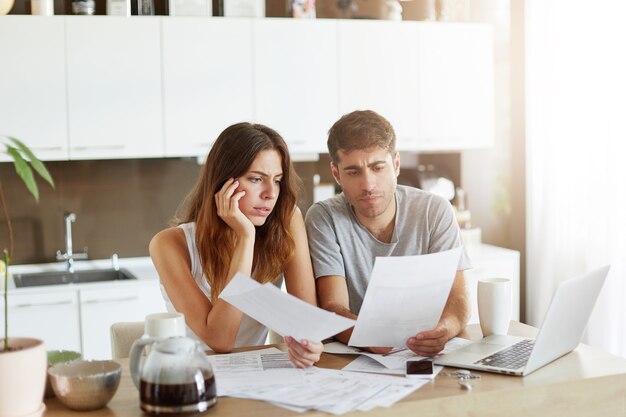 Pareja joven comprobando su presupuesto familiar