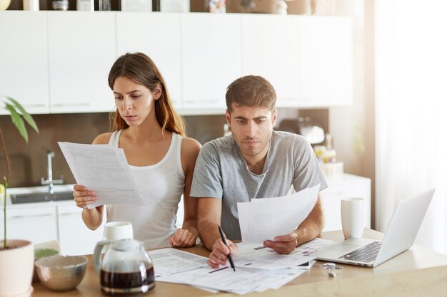 Pareja joven comprobando su presupuesto familiar