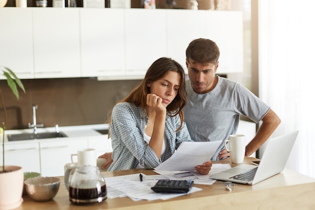 Pareja joven comprobando su presupuesto familiar