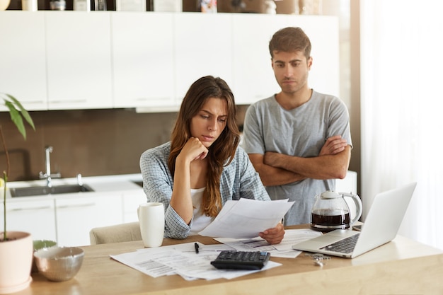 Pareja joven comprobando su presupuesto familiar