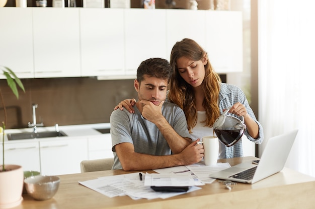 Pareja joven comprobando su presupuesto familiar