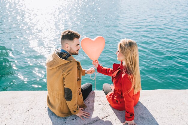 Pareja joven contenido posando con globo