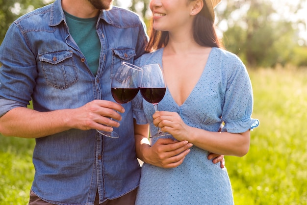 Foto gratuita pareja joven con copas de vino en el parque