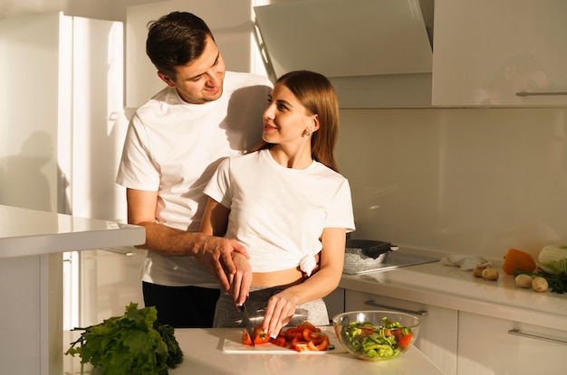 Pareja joven cortar verduras