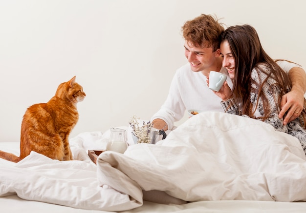 Pareja joven desayunando en la cama