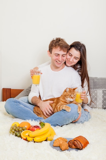 Foto gratuita pareja joven desayunando en la cama