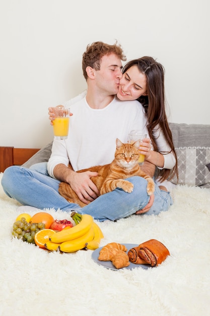 Foto gratuita pareja joven desayunando en la cama