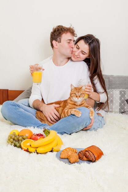 Pareja joven desayunando en la cama