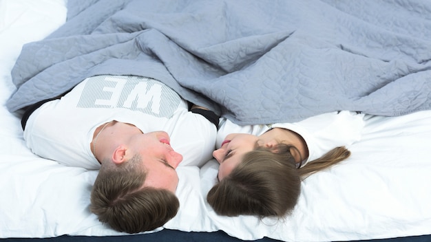 Foto gratuita pareja joven descansando en la cama blanca