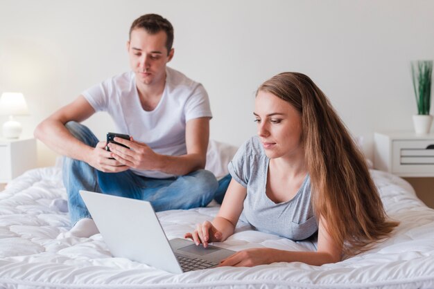 Pareja joven descansando con gadgets