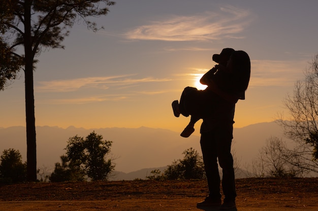 Pareja joven disfrutando del atardecer en la montaña