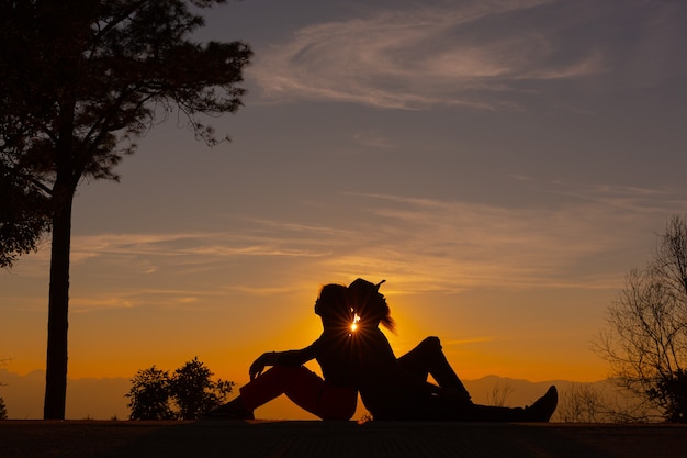 Pareja joven disfrutando del atardecer en la montaña