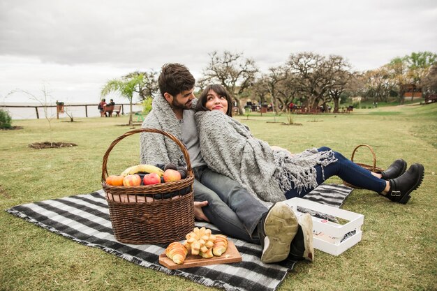 Pareja joven disfrutando en picnic en el parque