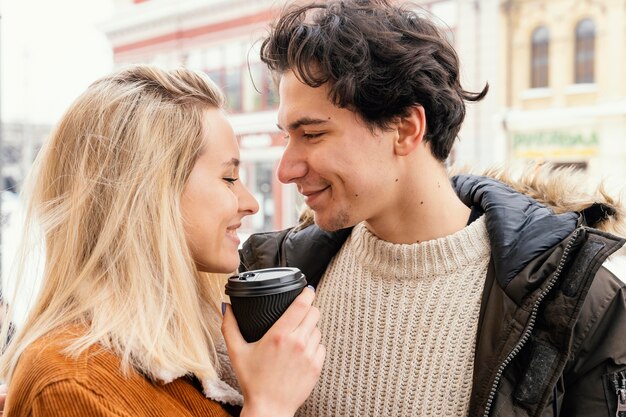 Pareja joven disfrutando de una taza de café al aire libre