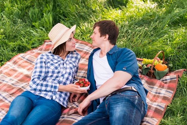 Pareja joven disfrutando de tiempo de picnic en el bosque