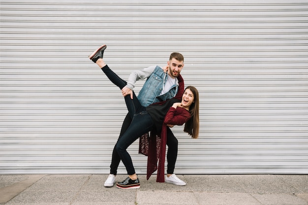 Pareja joven divirtiéndose enfrente de garaje