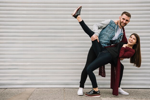 Pareja joven divirtiéndose enfrente de garaje